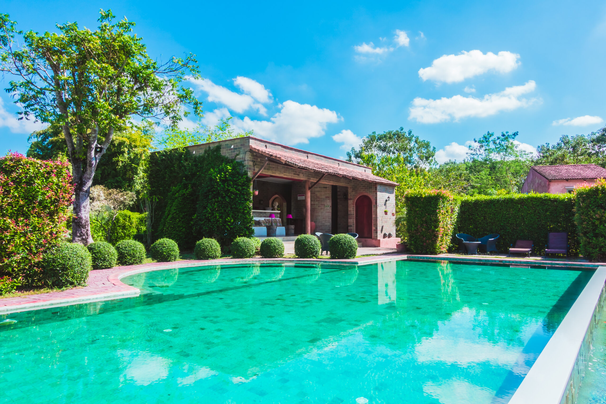 une jolie et grande piscine près d'une belle maison